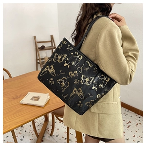Chic jacquard shoulder bag featuring artistic gold butterfly patterns on black fabric