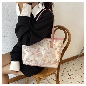 Detail of white jacquard tote bag with pink butterfly prints and fine leather shoulder strap