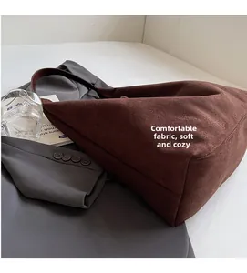 Detail of soft dark brown suede tote bag featuring a spacious triangular design and leather strap