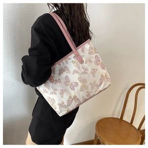 Lifestyle shot of large capacity tote bag with pink butterfly jacquard print and handles