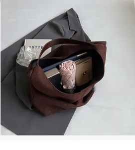 Macro view of spacious dark brown suede tote interior with umbrella and wallet