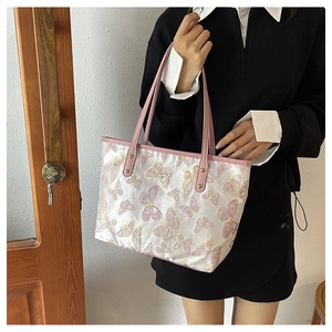 Detailed pink butterfly embroidery on a white jacquard tote bag with leather strap