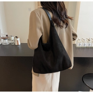 Close-up of black matte suede tote bag showing soft texture and spacious interior design