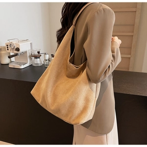 Large suede hobo bag shown in a side view profile during a stylish cafe lifestyle shoot