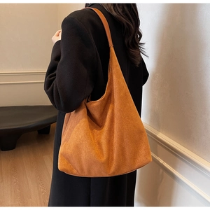 Minimalist caramel suede tote bag with large capacity, shown on model with black coat