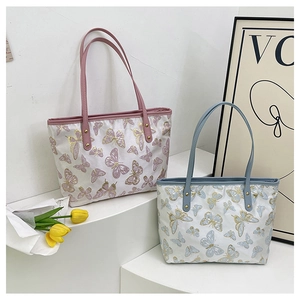 Detail of pink and blue jacquard tote bags with butterfly prints and metal rivets