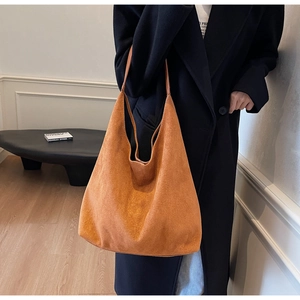 Macro view of the orange suede tote bag showing its soft texture and large capacity