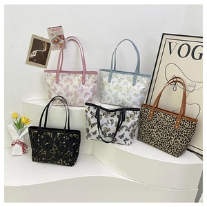 Detailed view of jacquard tote bags with butterfly prints and leopard pattern on display