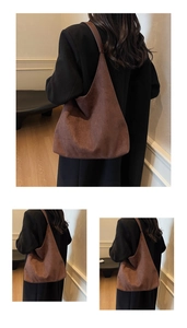 Detail view of a large brown suede tote bag showing soft texture and draped shoulder strap