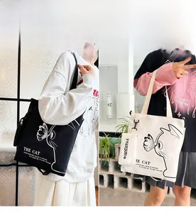 Detail of canvas tote bag showing cat illustration and detachable zipper coin purse