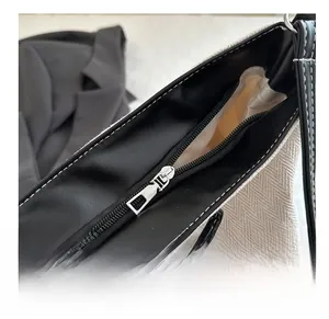 Close-up of smooth silver metal zipper and herringbone texture on stylish tote bag