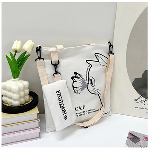 Detail of white canvas tote bag with black cat illustration and matching fashion pouch