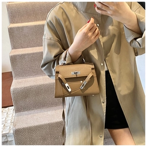 Detailed view of the brown lychee pattern leather texture and classic metal buckle closure