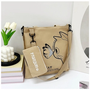 Detail of beige canvas tote with cat print, including detachable small pouch and strap