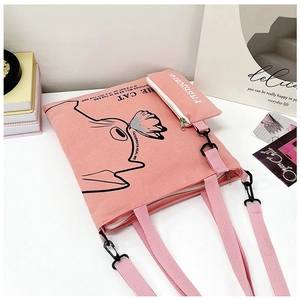 Detail of pink canvas tote bag and matching pouch with cat and butterfly illustration