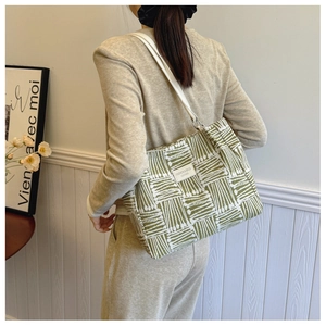 Detailed view of the large capacity green and white striped canvas tote bag on model