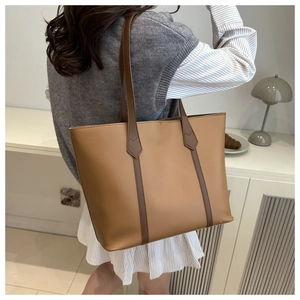 Minimalist khaki brown leather tote bag shown on shoulder for a stylish commuter look