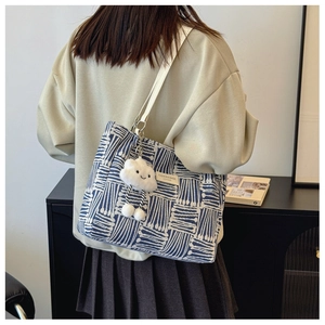Blue and white canvas tote bag with geometric patterns and plush pendant for women