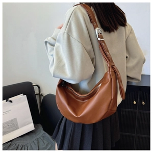 Detailed back view of a caramel brown faux leather crescent tote with wide shoulder strap