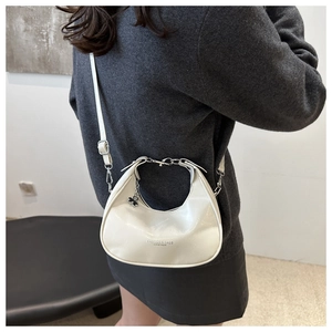 Detail view of cream crescent bag with silver chain and adjustable shoulder strap