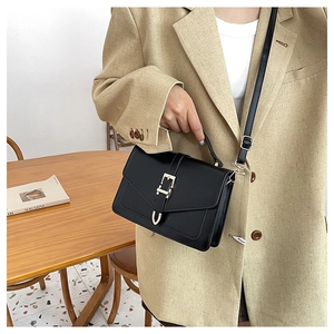 Detail of black matte PU leather mini crossbody bag with gold metal buckle and flap cover