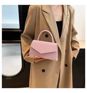 Détail du sac de soirée rose à paillettes avec chaîne dorée et poignée élégante