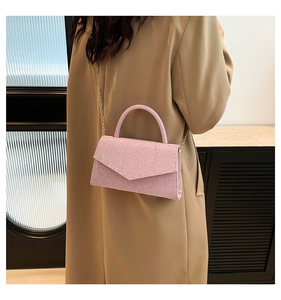 Detail of pink sequin crossbody bag with chain strap and elegant geometric flap