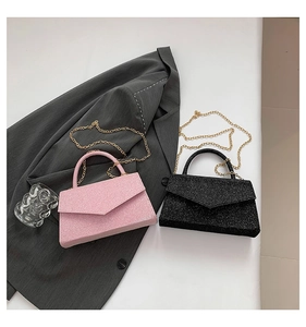 Detail view of sparkly pink and black square flap bags with elegant gold chain straps