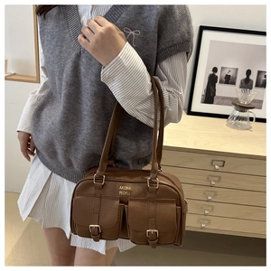Side view of vintage brown PU leather tote bag with gold buckles on model