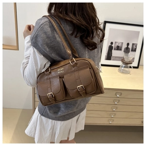 Detail of vintage brown Boston shoulder bag with dual front pockets and gold metal buckles