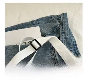 Close-up of durable woven white shoulder strap with black adjustable buckle on bag