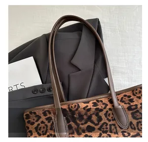 Dettaglio della borsa tote leopardata con manici in pelle marrone e morbido tessuto operato