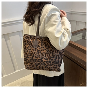 Macro detail of large leopard print tote bag with brown leather handles and stitching