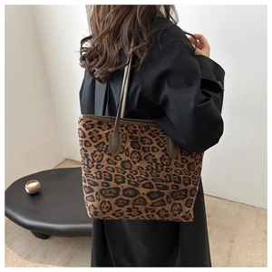 Leopard print tote bag shown on shoulder featuring classic brown and black patterns