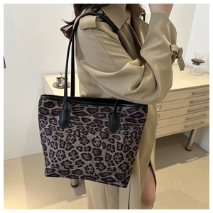 Detail of large tote bag with leopard print and black straps for daily fashion