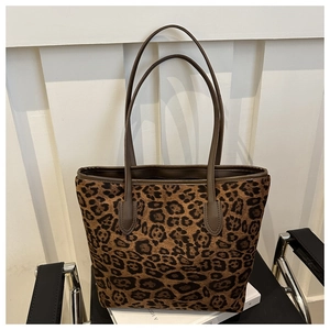Stylish large leopard print tote bag with brown leather handles on a minimalist background