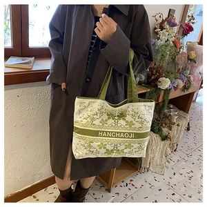 Détail du sac cabas en toile avec imprimé floral vintage vert et bandeau logo HANCHAOJI