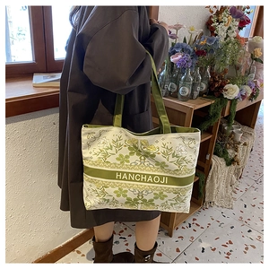 Vue détaillée du sac cabas en toile avec imprimés floraux verts et logo HANCHAOJI