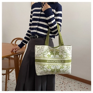 Détail du cabas en toile avec motifs floraux verts vintage et poignées de transport robustes