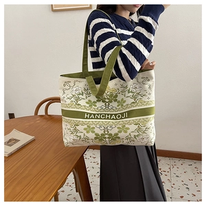 Détail du grand sac cabas en toile avec imprimé floral vert et poignées supérieures