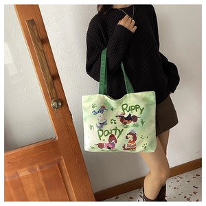 Détail du sac cabas en toile verte avec des illustrations mignonnes de teckels et texte