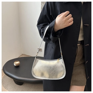 Detail of silver metallic hobo bag with gold zipper and textured synthetic leather finish