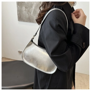 Sac hobo argenté métallisé avec texture plissée porté à l'épaule par un mannequin