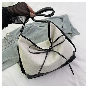 Detail of the high-contrast contrast tote with herringbone fabric and black leather bow