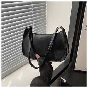 Détail du sac bandoulière vintage en cuir verni noir plissé avec accents dorés