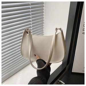 Détail du sac baguette en cuir verni blanc crème avec texture craquelée et boucle dorée