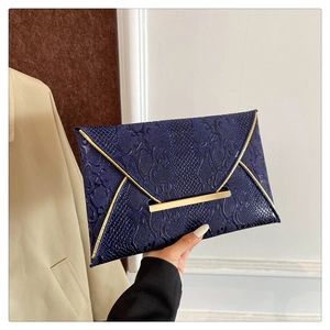 Detail view of navy blue envelope clutch featuring faux snakeskin texture and gold metal trim