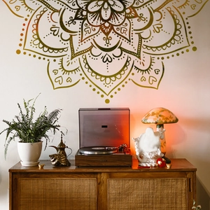 Detail of a large gold mandala wall sticker styled in a bohemian living room setting