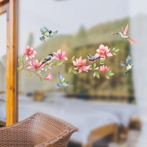 Detail of double-sided glass stickers with pink flowers and colorful birds for window decor