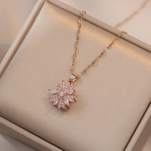 Elegant rose gold rotating flower necklace with white zircon pendants on jewelry box